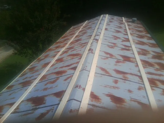 Rusted metal roof panels with new wood purlins before replacement — Storm Damage Roof Repair in Glade Hill by Roofing Brothers