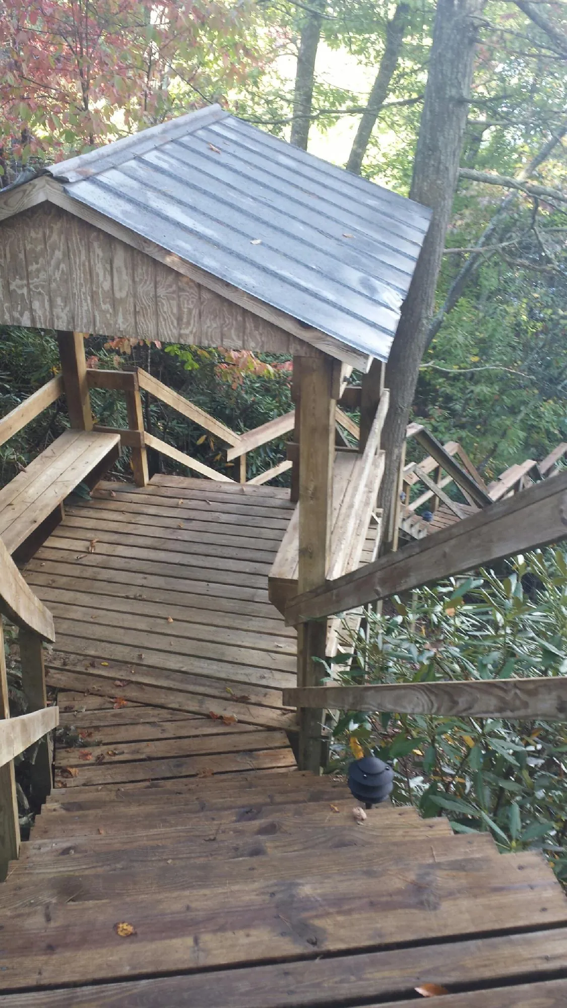 Metal roofed shelter over wooden steps on a wooded walkway — Skylight Repair & Installation work by our crew in Glade Hill